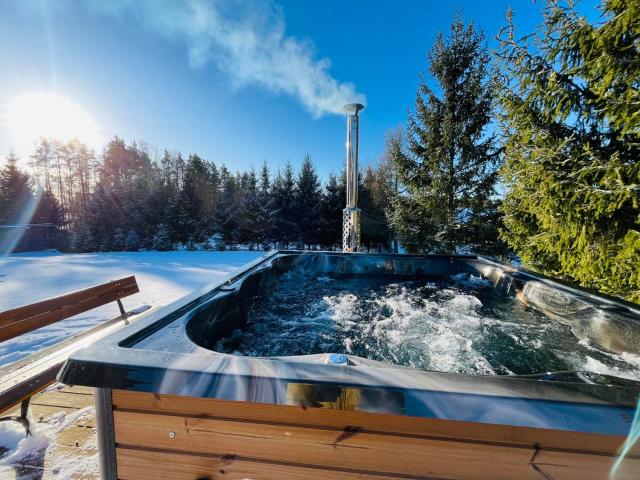 Domek z kominkiem nad jeziorem z jacuzzi ogrodowym